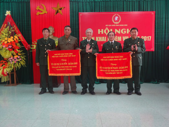 Đại diện Hội CCB tỉnh trao cờ thi đua xuất sắc của Trung ương Hội CCB Việt Nam cho Hội CCB thị xã Ba Đồn và Bố Trạch