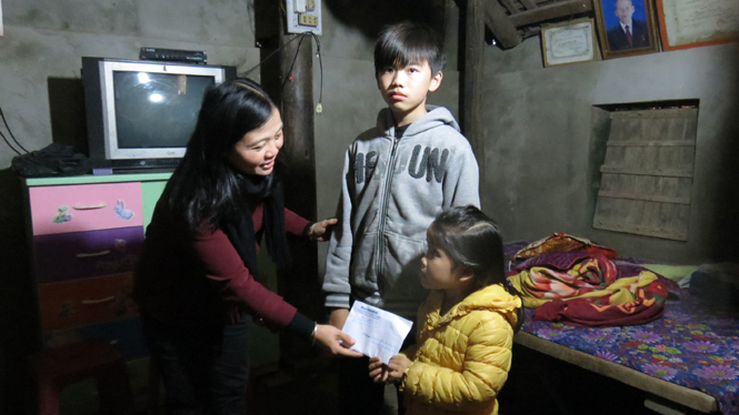 Đại diện Ban biên tập Báo Quảng Bình trao quà hỗ trợ của nhà hảo tâm cho anh em Huy, Trang.