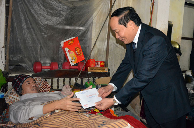  Đồng chí Trần Xuân Vinh, Ủy viên Ban Thường vụ, Trưởng ban Tổ chức Tỉnh ủy tặng quà cho bệnh binh Hoàng Văn Sơn, ở TK 1, thị trấn Quán Hàu.