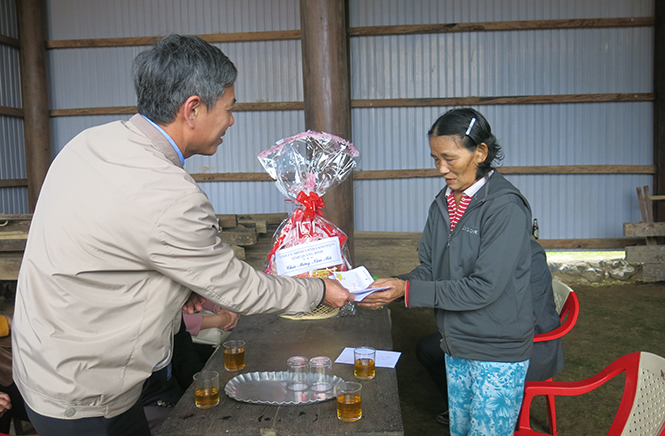  Đồng chí Đinh Hữu Niên, Chủ tịch UBND huyện Minh Hóa tặng quà cho đối tượng chính sách ở xã Tân Hóa.