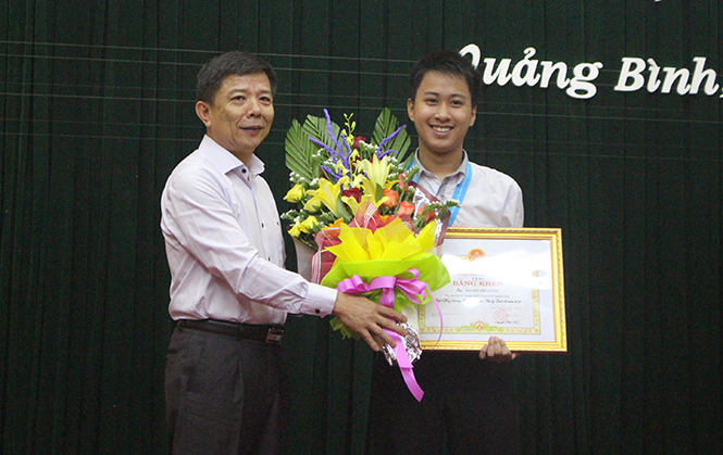 Đồng chí Nguyễn Hữu Hoài, Phó Bí thư Tỉnh ủy, Chủ tịch UBND tỉnh trao thưởng cho học sinh Nguyễn Thế Quỳnh.