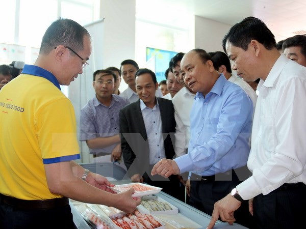 Thủ tướng Nguyễn Xuân Phúc thăm các gian hàng của các công ty trưng bày bên lề hội nghị. (Ảnh: Kim Há/TTXVN)