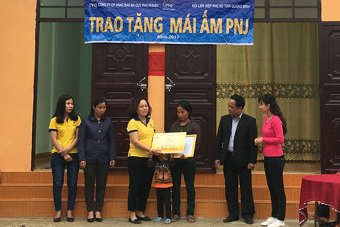 Đại diện Quỹ từ thiện PNJ tặng quà cho gia đình chị Hoàng Thị Tuyết ở xã Phù Hóa (Quảng Trạch). 