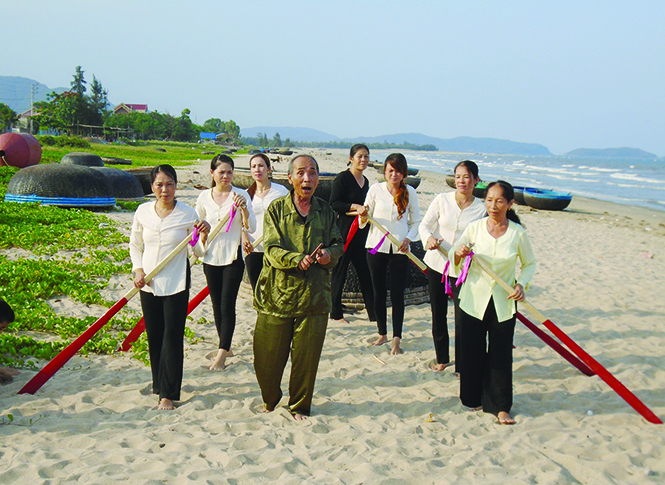 Nghệ nhân ưu tú Phạm Ngọc Thức đang luyện tập cho đội chèo cạn trên bãi biển.
