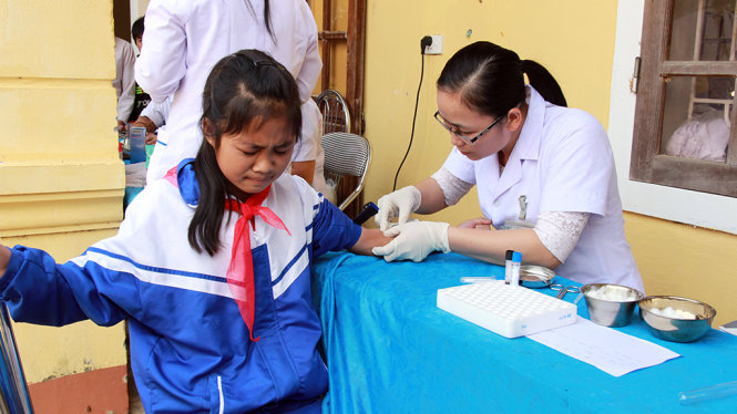 Bác sĩ lấy mẫu máu học sinh Trường tiểu học - THCS Hạnh Dịch, huyện Quế Phong (Nghệ An) để xét nghiệm sau khi nhiều học sinh bị viêm cầu thận cấp - Ảnh: LÀI HỒ