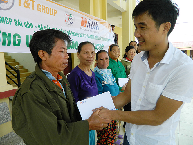 Ảnh 3 : Người dân thị xã Ba Đồn nhận tiền hỗ trợ lũ lụt từ các đoàn thiện nguyện.