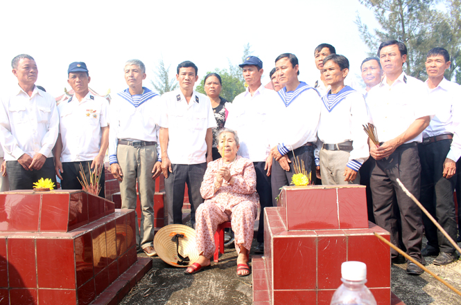 Mẹ Hồ Thị Đức, thân mẫu Anh hùng liệt sỹ Trần Văn Phương cùng đồng đội Gạc Ma trước phần mộ của anh