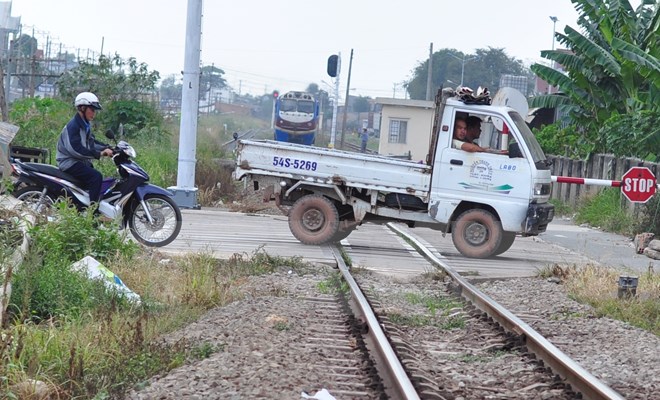 Đường ngang dân sinh ở phường Tân Hòa, Biên Hòa (Đồng Nai) người tham gia giao thông vẫn cố tình băng qua đường sắt dù tàu đang đến gần. (Ảnh: Công Phong/TTXVN)