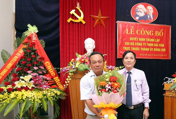 Đại diện lãnh đạo Thành ủy trao quyết định và tặng hoa chúc mừng Chi bộ Đảng Công ty TNHH Hải Vân.