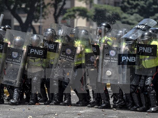 Cảnh sát Venezuela trong cuộc xung đột với người biểu tình ở Caracas ngày 4-4. (Nguồn: AFP/TTXVN)