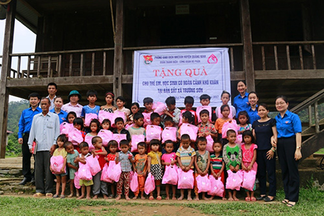 Trẻ em nghèo ở Bản Sắt phấn khởi với món quà của Đoàn thanh niên Phòng giao dịch NHCSXH huyện Quảng Ninh trao tặng