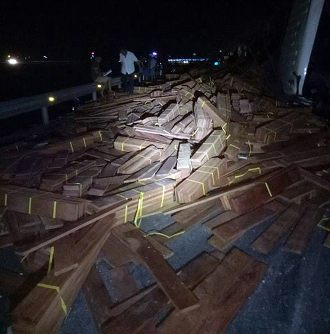 Hàng chục tấn gỗ tràn ra đường khi xe đầu kéo mất lái.