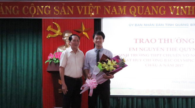 Đại diện lãnh đạo Hội Khuyến học tỉnh trao thưởng cho em Nguyễn Thế Quỳnh.