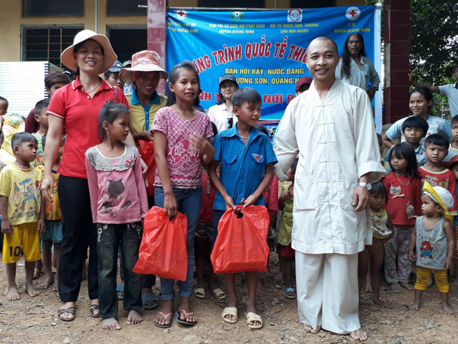 Đại diện lãnh đạo Hội Chữ thập đỏ huyện và nhà tài trợ trao quà cho các em thiếu nhi bản Nước Đắng.
