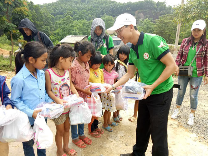 Các tình nguyện viên trong CLB nét bút xanh miền Trung trao quà cho trẻ em bản Khe Rôông