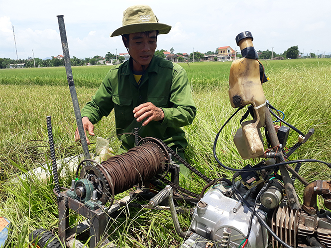Anh Trần Văn Chức đang vận hàng máy tời vận chuyển lúa.