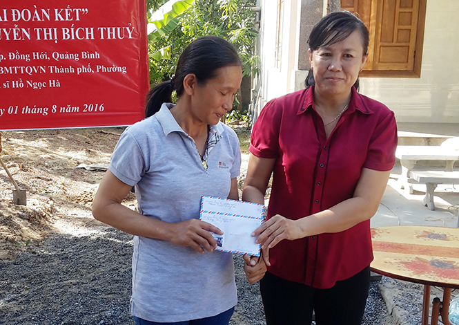 Chị Đoàn Thị Thủy trao quà cho một hộ nghèo của phường được hỗ trợ xây nhà Đại đoàn kết.