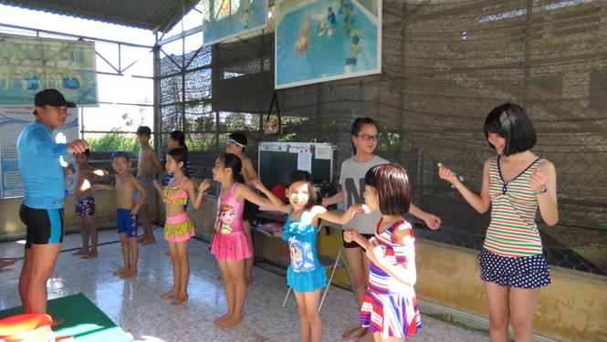 Trước khi vào bể bơi, các em được thầy giáo hướng dẫn khởi động kỹ từng động tác, tránh tình trạng ngợp nước.