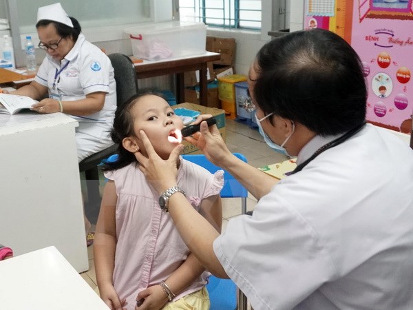 Bác sỹ Bệnh viện Nhi đồng 1 Thành phố Hồ Chí Minh thăm khám cho trẻ. (Ảnh: Phương Vy/TTXVN)