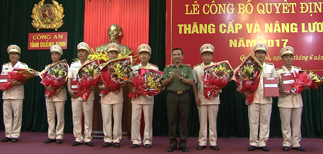 Đồng chí Giám đốc Công an tỉnh Từ Hồng Sơn, trao quyết định và tặng hoa cho các cán bộ được thăng cấp, nâng lương.