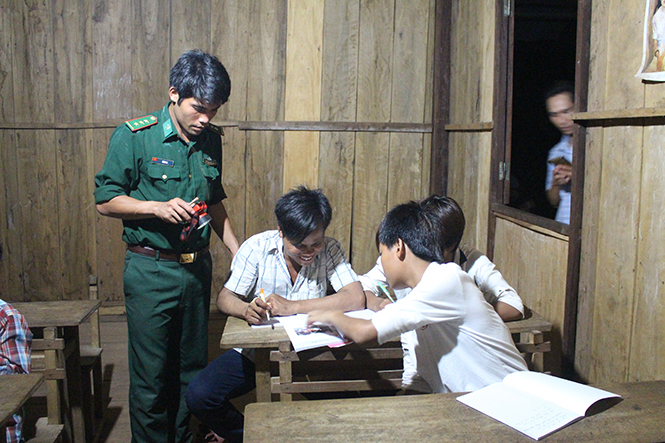 Thượng úy Hồ Manh, Đội trưởng Đội vận động quần chúng, Đồn Biên phòng Làng Mô, hướng dẫn học viên trong lớp xóa mù tập viết và tập đánh vần.