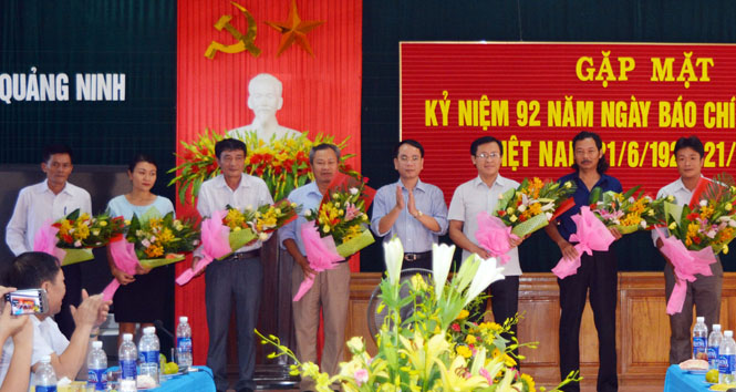 Đồng chí Bí thư Huyện ủy Quảng Ninh Phan Mạnh Hùng tặng hoa chúc mừng các nhà báo. 