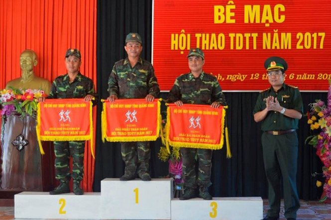 Đại diện lãnh đạo Bộ chỉ huy BĐBP tỉnh tặng cờ cho 3 đơn vị nhất, nhì, ba toàn đoàn.                                     (Ảnh: Hoài Nam)