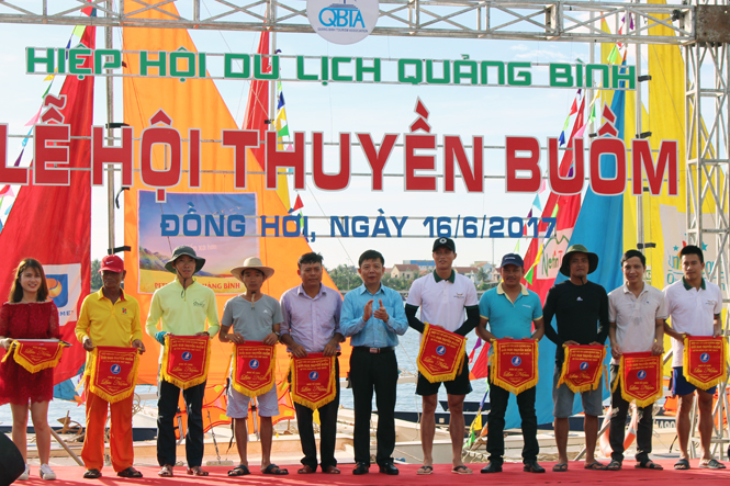 Đồng chí Nguyễn Hữu Hoài, Phó Bí thư Tỉnh ủy, Chủ tịch UBND tỉnh trao cờ lưu niệm cho các đội đua thuyền buồm.