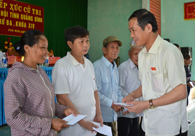 Đồng chí Trần Công Thuật, Phó Bí thư Thường trực Tỉnh uỷ, Trưởng đoàn đại biểu Quốc hội tỉnh trao quà của các gia đình chính sách trên địa bàn huyện.