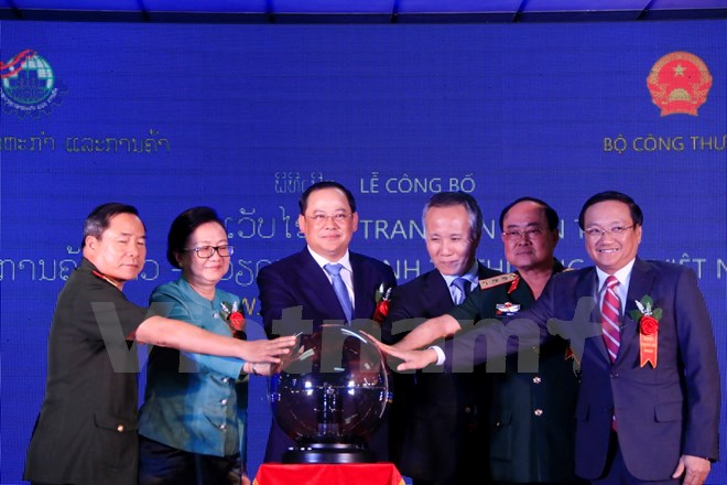 Lãnh đạo Bộ Quốc phòng và Bộ Công Thương hai nước đang cùng nhau khai trương Trang tin điện tử kinh tế thương mại Việt Nam-Lào. (Ảnh: Phạm Kiên/Vietnam+)