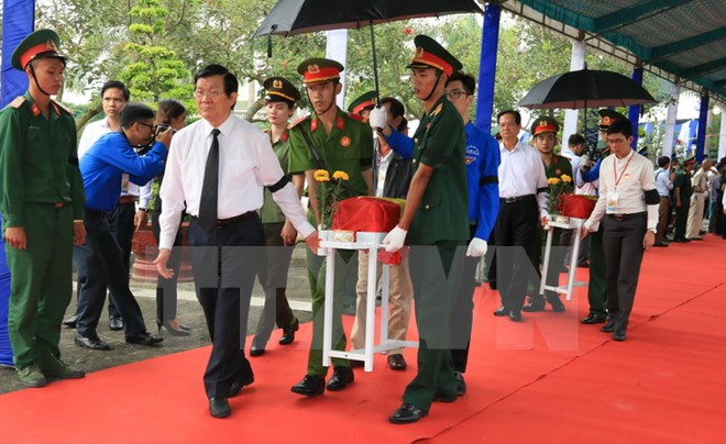 Nguyên Chủ tịch nước Trương Tấn Sang tiễn đưa hài cốt liệt sỹ đến nơi an táng. (Ảnh: Sỹ Tuyên/TTXVN)