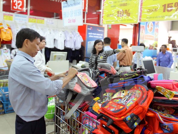 Người tiêu dùng mua sản phẩm bình ổn giá và khuyến mại năm học mới tại Co.op mart Nguyễn Đình Chiểu ở TP Hồ Chí Minh. (Ảnh: Thanh Vũ/TTXVN)