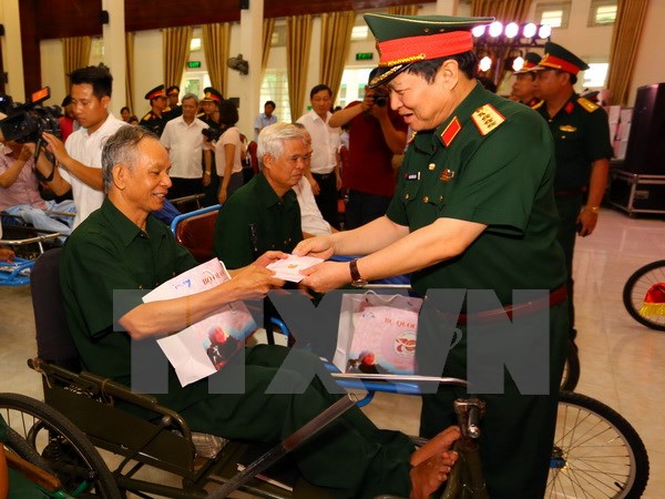 Bộ trưởng Bộ Quốc phòng Ngô Xuân Lịch thăm hỏi và tặng quà cho thương binh đang điều dưỡng tại Trung tâm Điều dưỡng thương binh Thuận Thành. (Ảnh: Anh Tuấn/TTXVN)