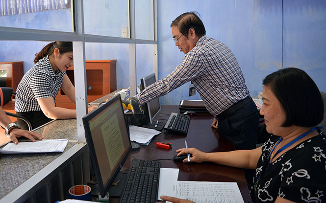 Cán bộ Chi cục Thuế huyện Quảng Ninh hướng dẫn tận tình cho người đến nộp thuế.