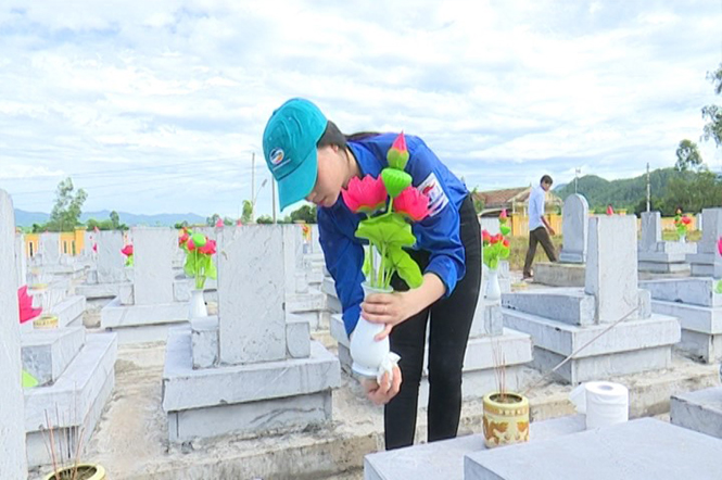  Đoàn viên thanh niên huyện Tuyên Hóa gắn bình hoa sen lên từng phần mộ liệt sỹ.