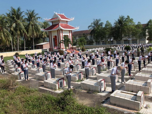 Các thế hệ học sinh xã Hoài Xuân huyện Hoài Nhơn, Bình Định thường xuyên chăm sóc phần mộ liệt sỹ tại nghĩa trang liệt sỹ của xã. (Ảnh: Anh Tuấn/TTXVN)