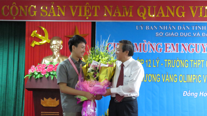 Đồng chí Hoàng Đăng Quang, Ủy viên Trung ương Đảng, Bí thư Tỉnh ủy, Chủ tịch HĐND tỉnh tặng hoa, phần thưởng chúc mừng học sinh Nguyễn Thế Quỳnh.