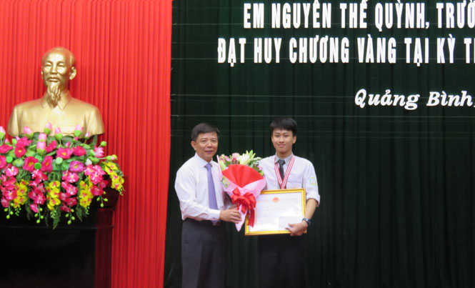 Đồng chí Nguyễn Hữu Hoài, Phó Bí thư Tỉnh uỷ, Chủ tịch UBND tỉnh, Chủ tịch Hội đồng TĐ - KT tỉnh, trao Bằng khen và phần thưởng cho em Nguyễn Thế Quỳnh.