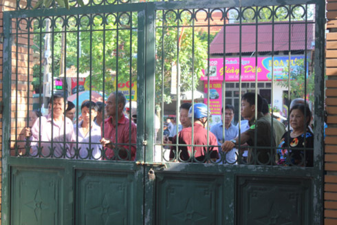 Nhiều người dân đứng phía ngoài cổng sắt của tòa án theo dõi phiên xử