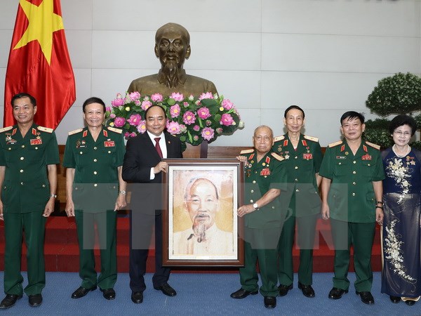 Thủ tướng Nguyễn Xuân Phúc tặng bức ảnh chân dung Chủ tịch Hồ Chí Minh cho Hội truyền thống Trường Sơn - đường Hồ Chí Minh. (Ảnh: Thống Nhất/TTXVN)