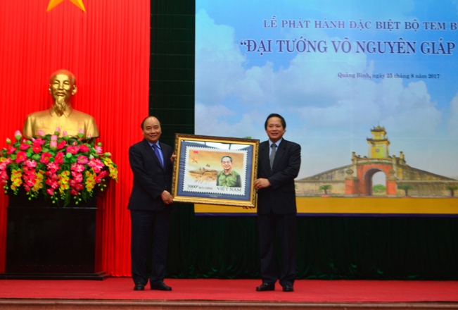 Đại diện lãnh đạo Bộ Thông tin và Truyền thông trao tặng Thủ tướng Chính phủ Nguyễn Xuân Phúc bức tranh tem về Đại tướng. 