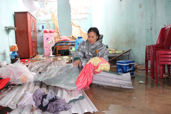 Chị Bùi Thị Nga, thôn Thọ Sơn, xã Quảng Đông đội mưa lượm lặt những vật dụng còn lành lặn còn sót lại.