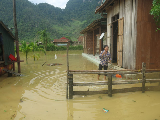 Người dân xã Tân Hóa đang tận dụng nguồn nước lũ để vệ sinh nhà cửa, đường sá