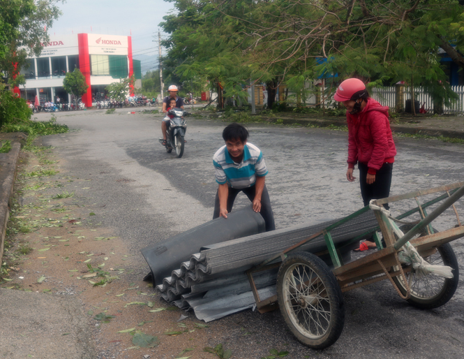 Người dân thị trấn Đồng Lê, huyện Tuyên Hoá đi mua tấm phi bờ rô xi măng để lợp lại nhà bị tốc mái do bão