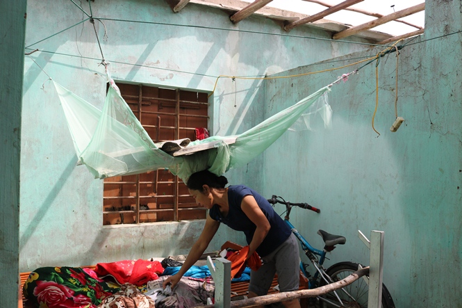Chị Nguyễn Thị Lan, thôn Thọ Sơn, xã Quảng Đông gom nhặt lại đồ đạc bị ướt nước mưa