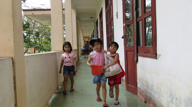 Các em bé cũng phụ giúp ba mẹ dọn đồ đạc từ nơi sơ tán (phòng học của trường) về lại khu nội trú.