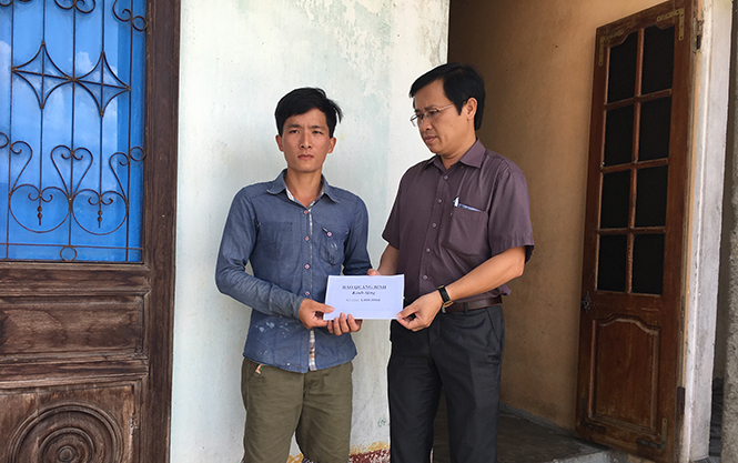  Đồng chí Hoàng Hữu Thái, Tổng biên tập Báo Quảng Bình động viên, tặng quà người thân của bà Phan Thị Hoa (thôn 5), bị thương do bão số 10 gây ra.