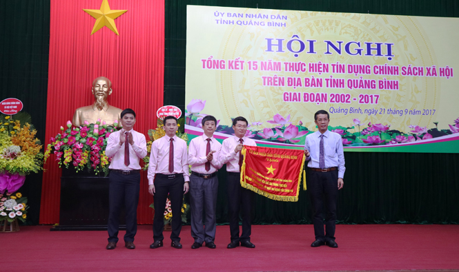 Đồng chí Trần Công Thuật, Phó Bí thư Thường trực Tỉnh ủy, Trưởng đoàn đại biểu Quốc hội tỉnh trao Cờ thi đua cho đại diện Ngân hàng CSXH-Chi nhánh Quảng Bình.