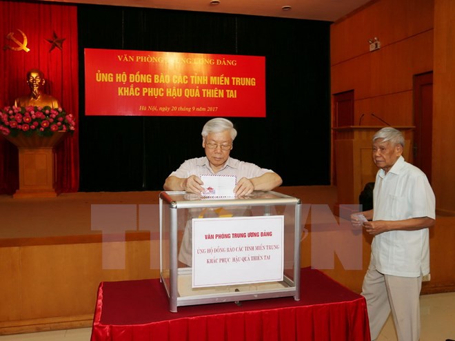 Tổng Bí thư Nguyễn Phú Trọng, nguyên Tổng Bí thư Lê Khả Phiêu tham gia quyên góp ủng hộ đồng bào khắc phục hậu quả thiên tai. (Ảnh: Trí Dũng/TTXVN)