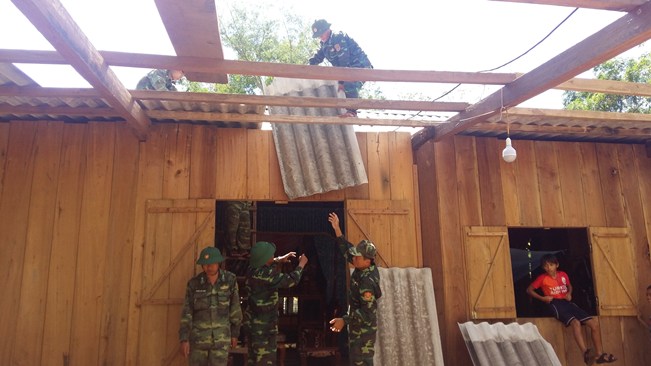 Cán bộ, chiến sĩ Đồn Biên phòng Cha Lo giúp đồng bào khắc phục nhà ở bị hư hỏng sau cơn bão số 10 vừa qua.